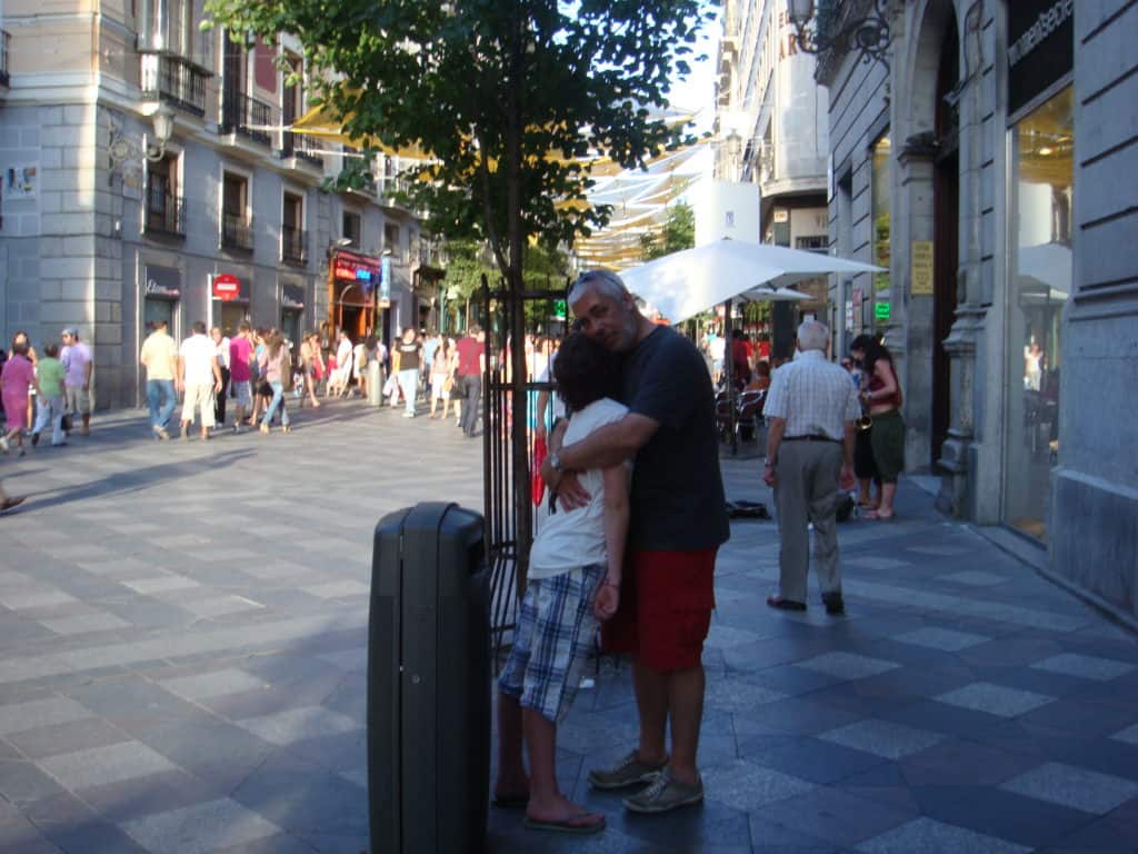 Travel picture showing a man hugging his kid, who is apparently very tired