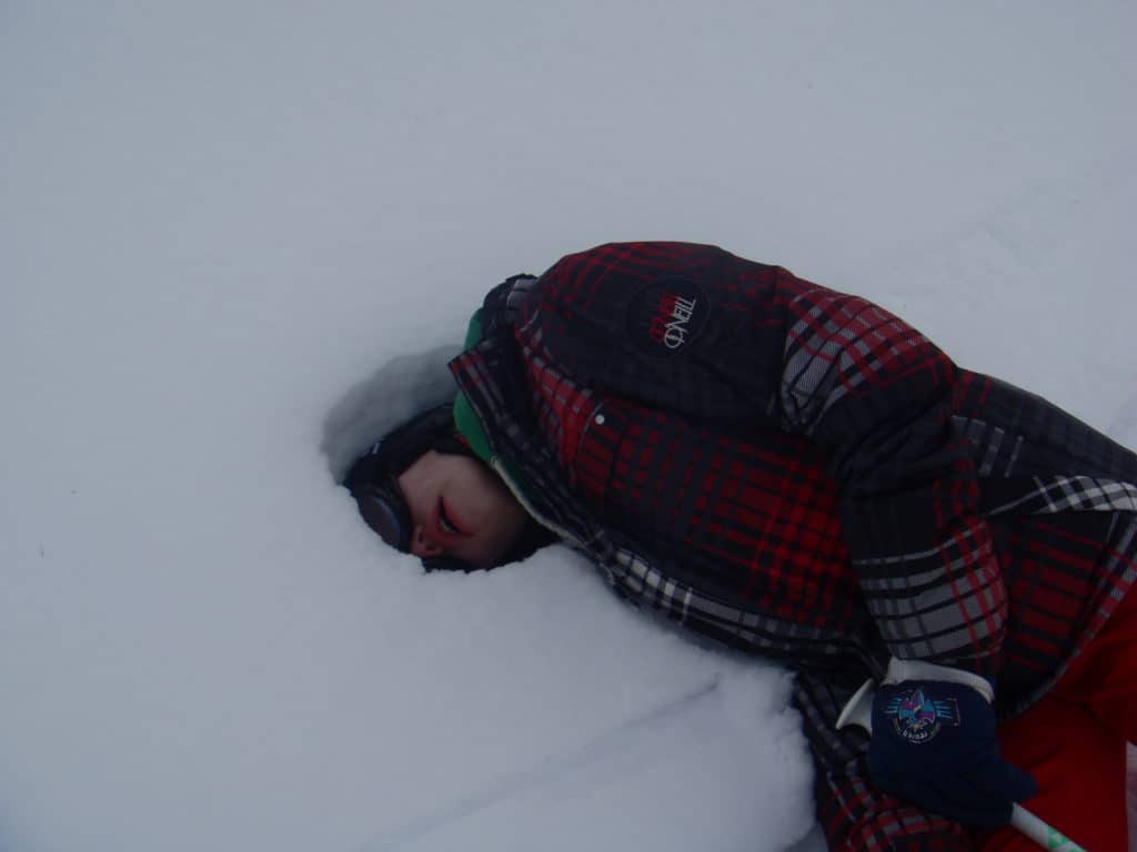 15-year-old guy on a ski trip sticking his head in the snow