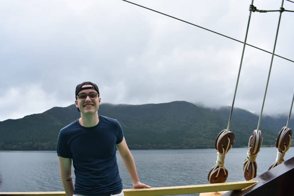 Me standing on a pirate boat with Japanese nature in the background