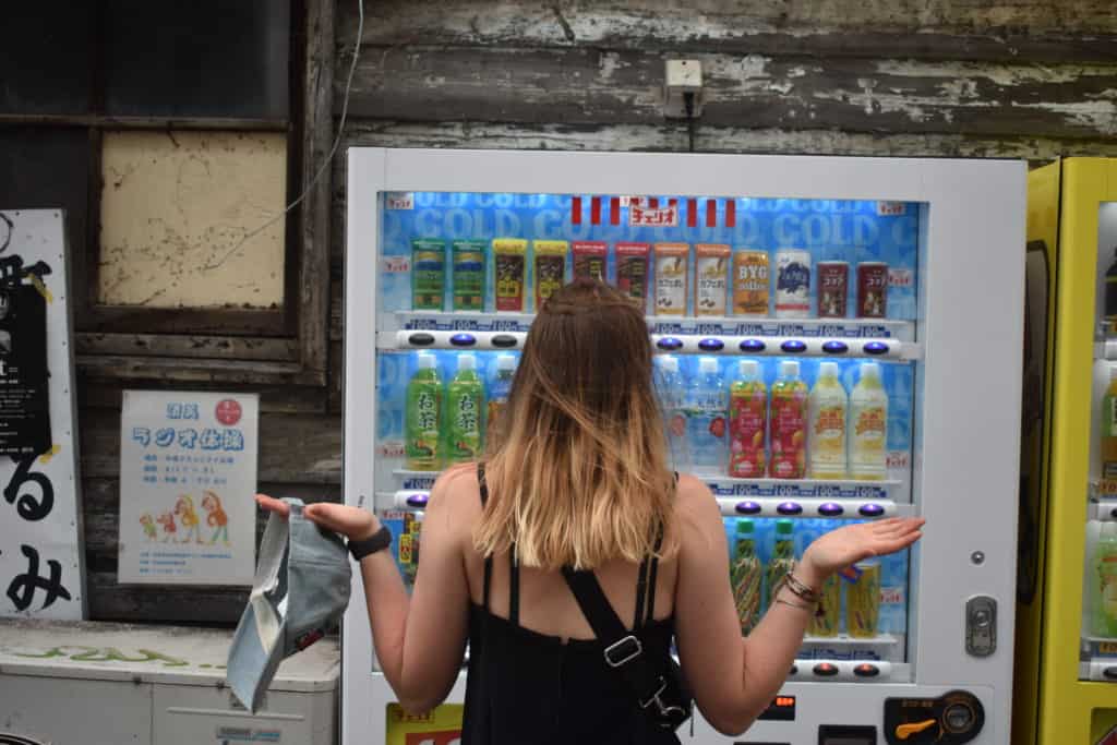 My sister standing in front of a Japanese drink vending machine, unable to make a choice