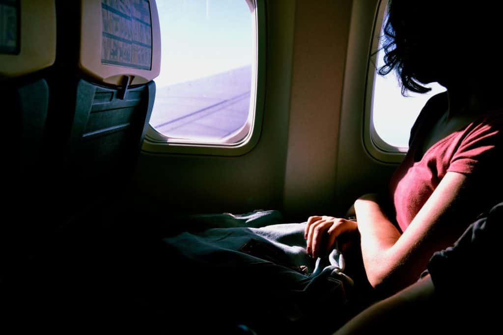 Woman sitting in window seat on long flight