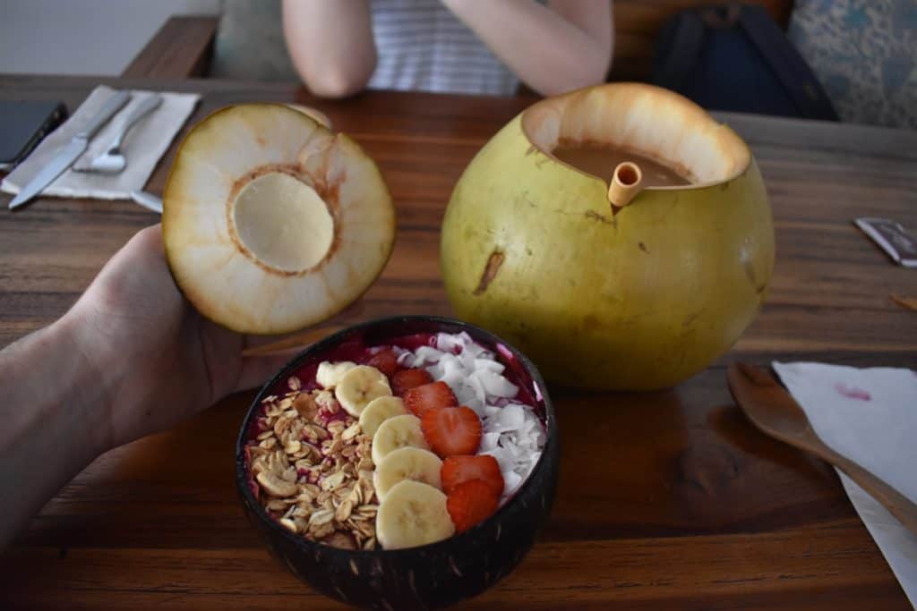 Dragonfruit breakfast bowl and young coconut in restaurant in Bali
